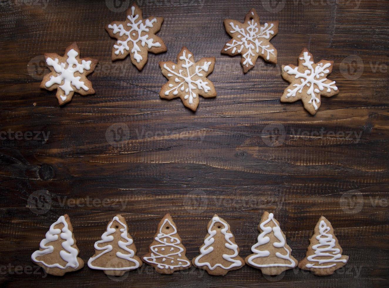 Kerst achtergrond met koekjes versierd met slagroom, op een houten bord. foto