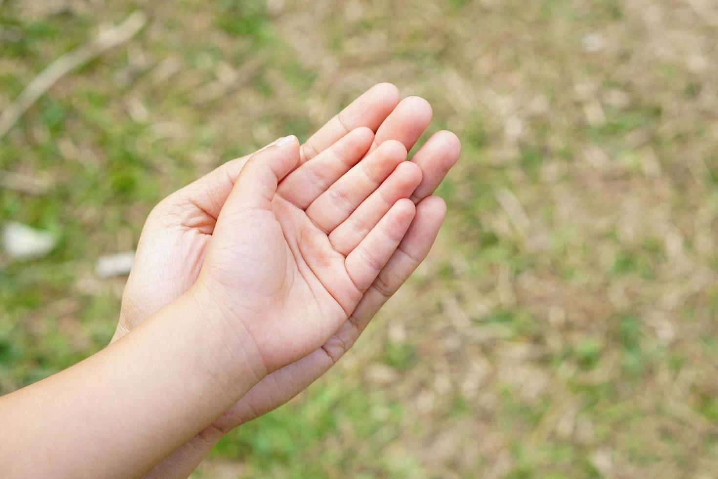 moeder en kind houden elkaars hand vast om iets te ontvangen foto