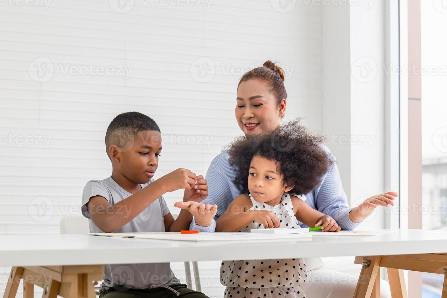 oma en kleinkinderen vrolijk spelen in woonkamer, kinderen spelen spel met grootouders foto