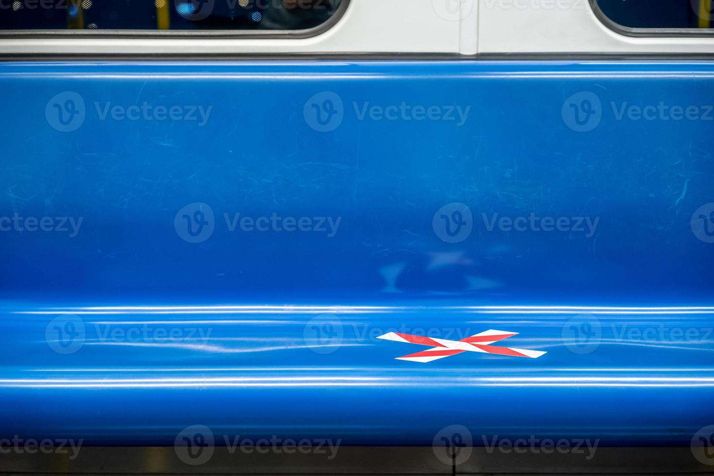blauwe zitrij in de trein met gekruiste markeringstape in de periode van coronavirus covid-19. het betekent sociale afstand in transport. foto