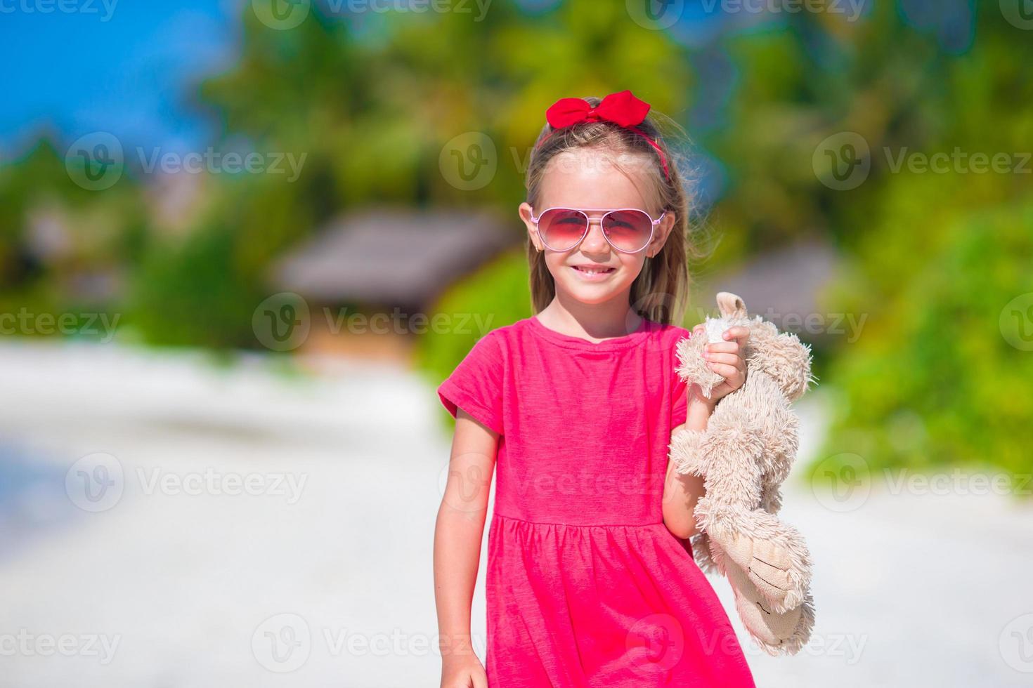 schattig klein meisje speelt met speelgoed tijdens strandvakantie foto