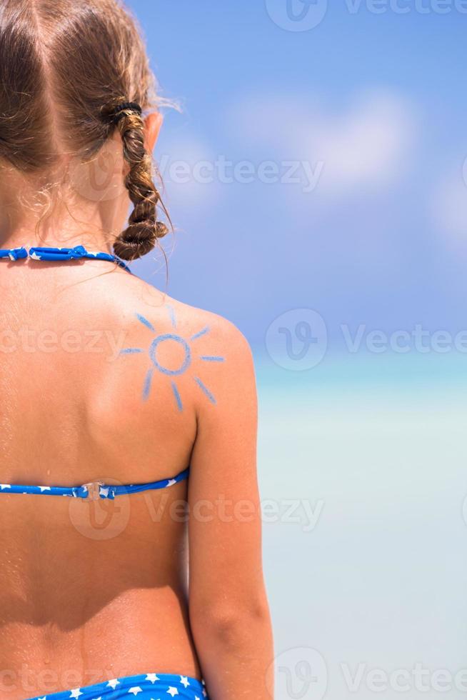 close-up zon geschilderd door zonnebrandcrème op schouder van het kind foto