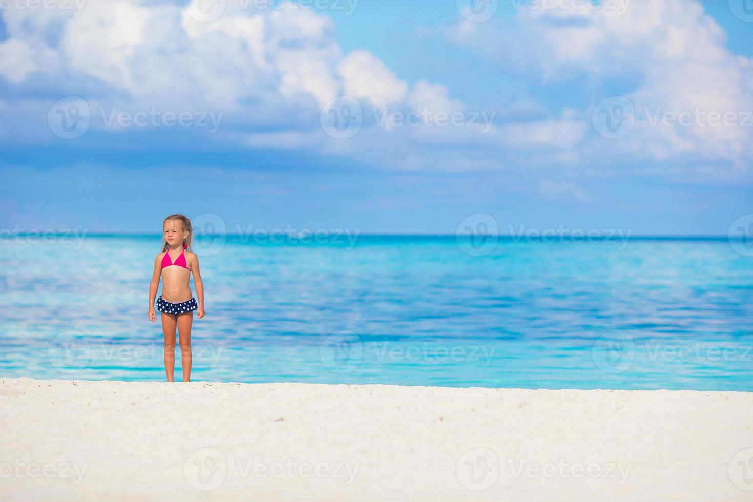 schattig klein meisje op het strand tijdens de zomervakantie foto