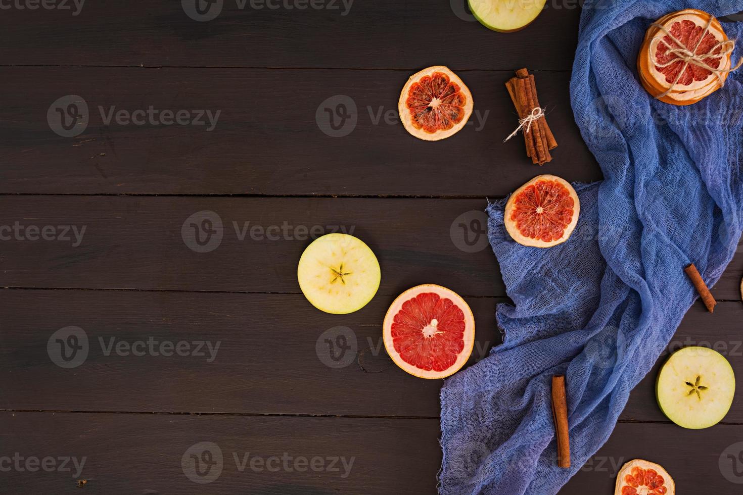 appel, grapefruit en kaneel op houten achtergrond. ingrediënt voor warme glühwein. bovenaanzicht foto