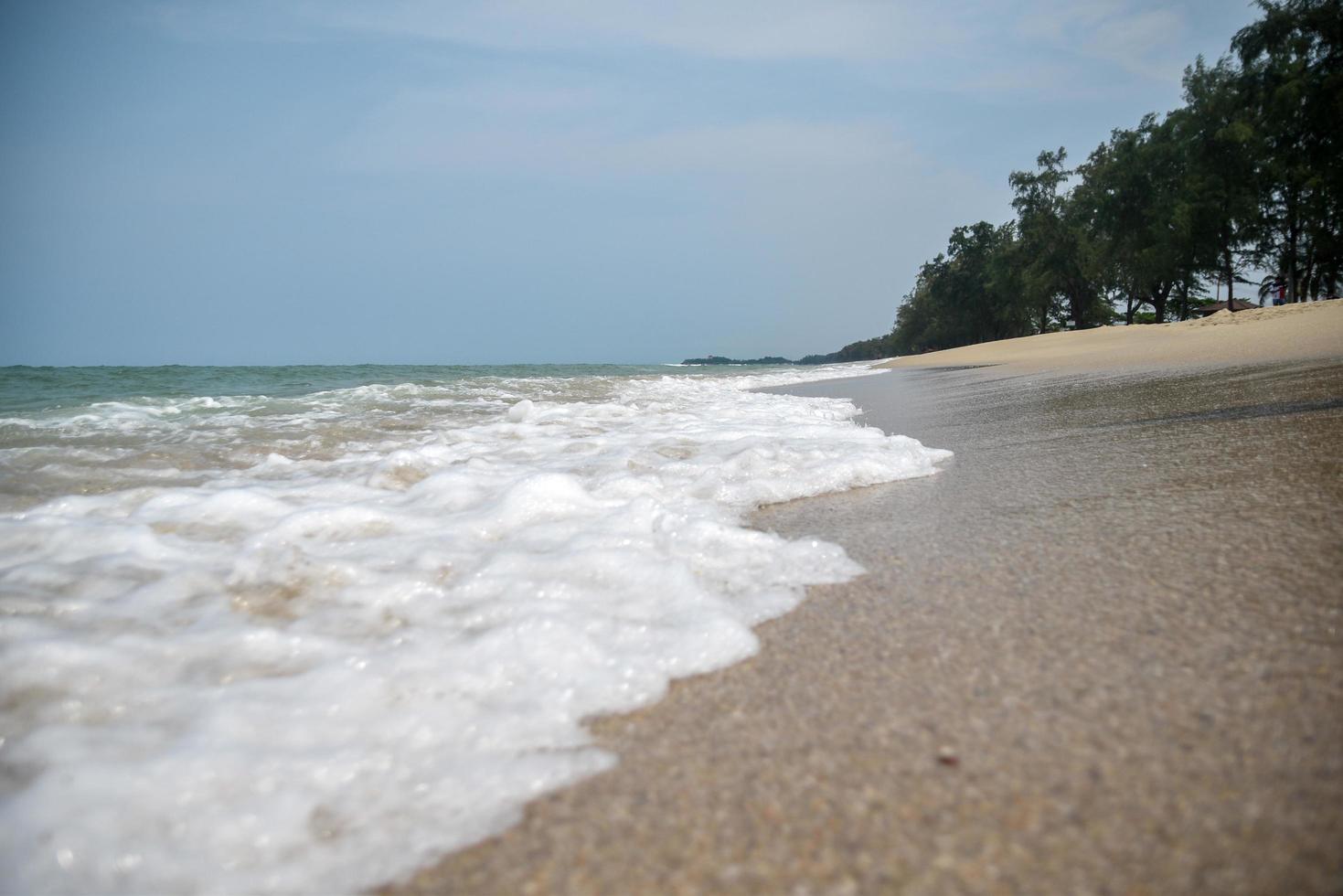 groothoek opname van zeewater dat het strand raakt, witte spons van de zee, zomer natuur achtergrond afbeelding concept. foto