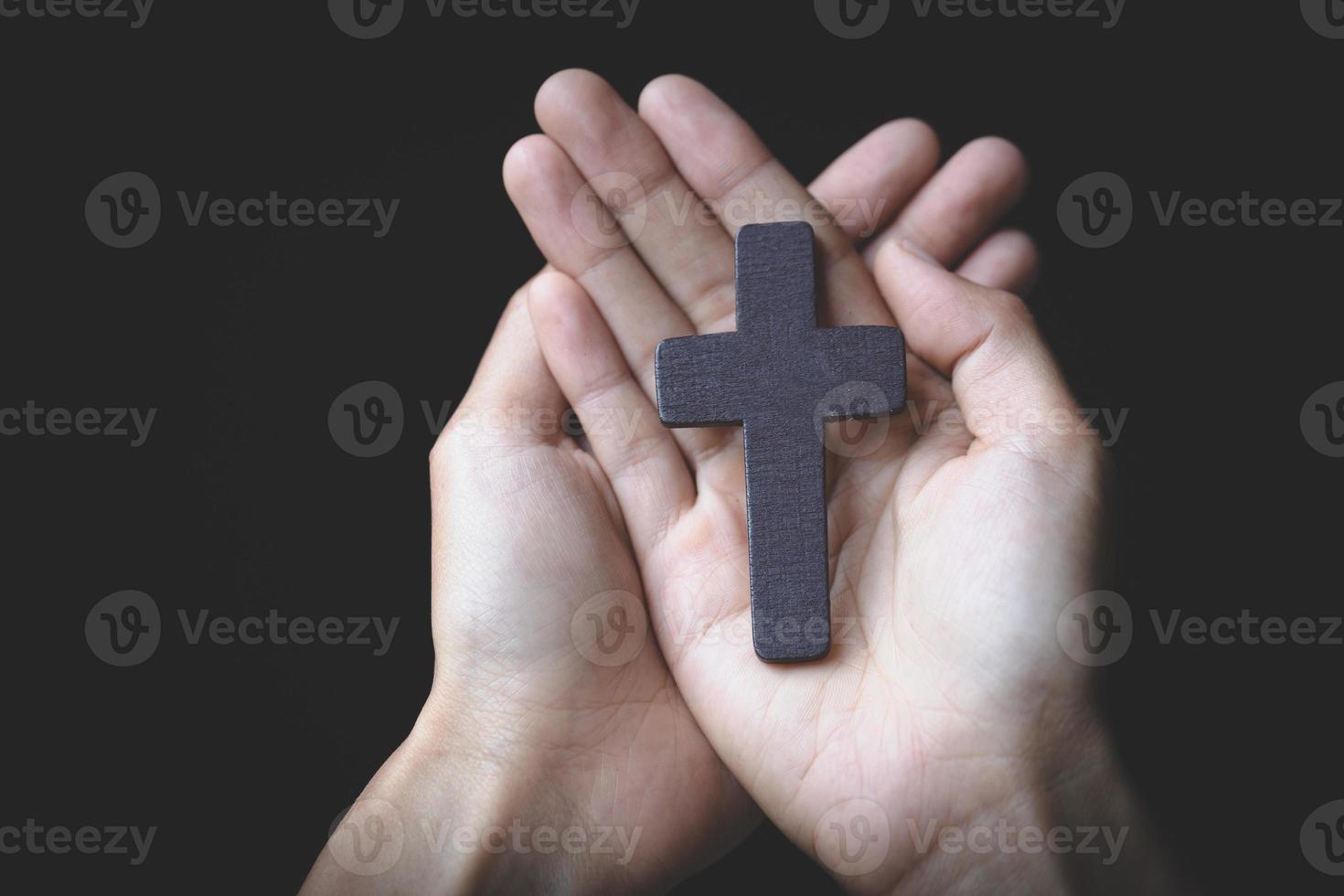 menselijke hand houdt kruis, aanbidding, zonden en gebed, religieus concept. eucharistie therapie zegen god helpen bekeren katholieke pasen leende geest bidden. foto