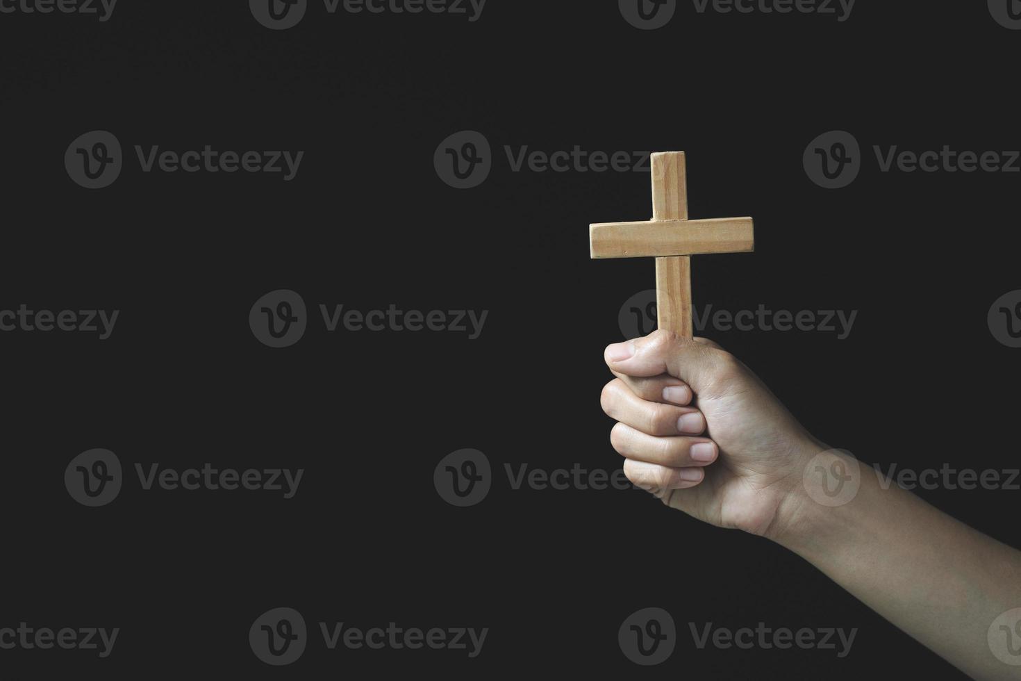 menselijke hand houdt kruis, aanbidding, zonden en gebed, religieus concept. eucharistie therapie zegen god helpen bekeren katholieke pasen leende geest bidden. foto