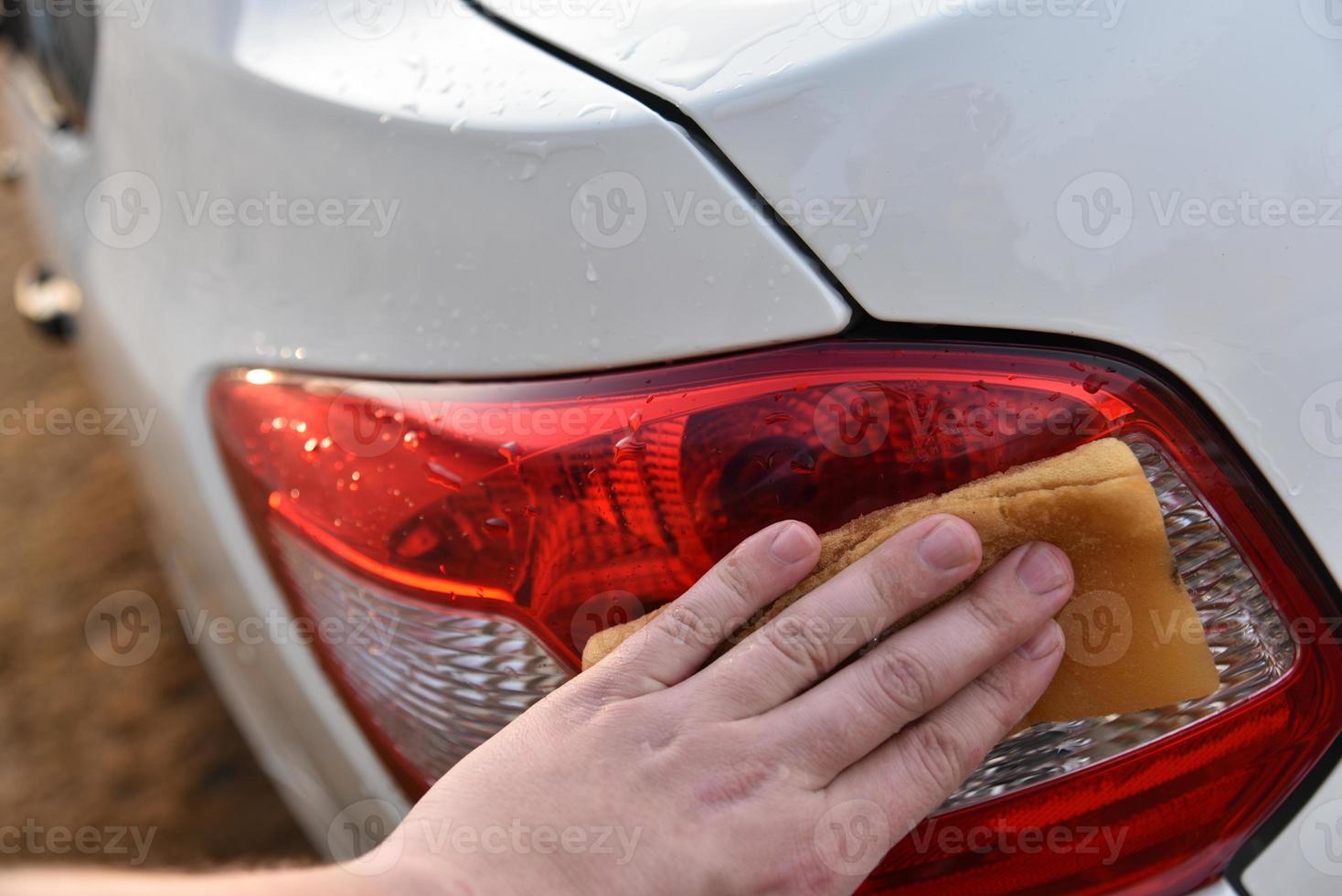 een witte auto met de hand wassen met een spons foto