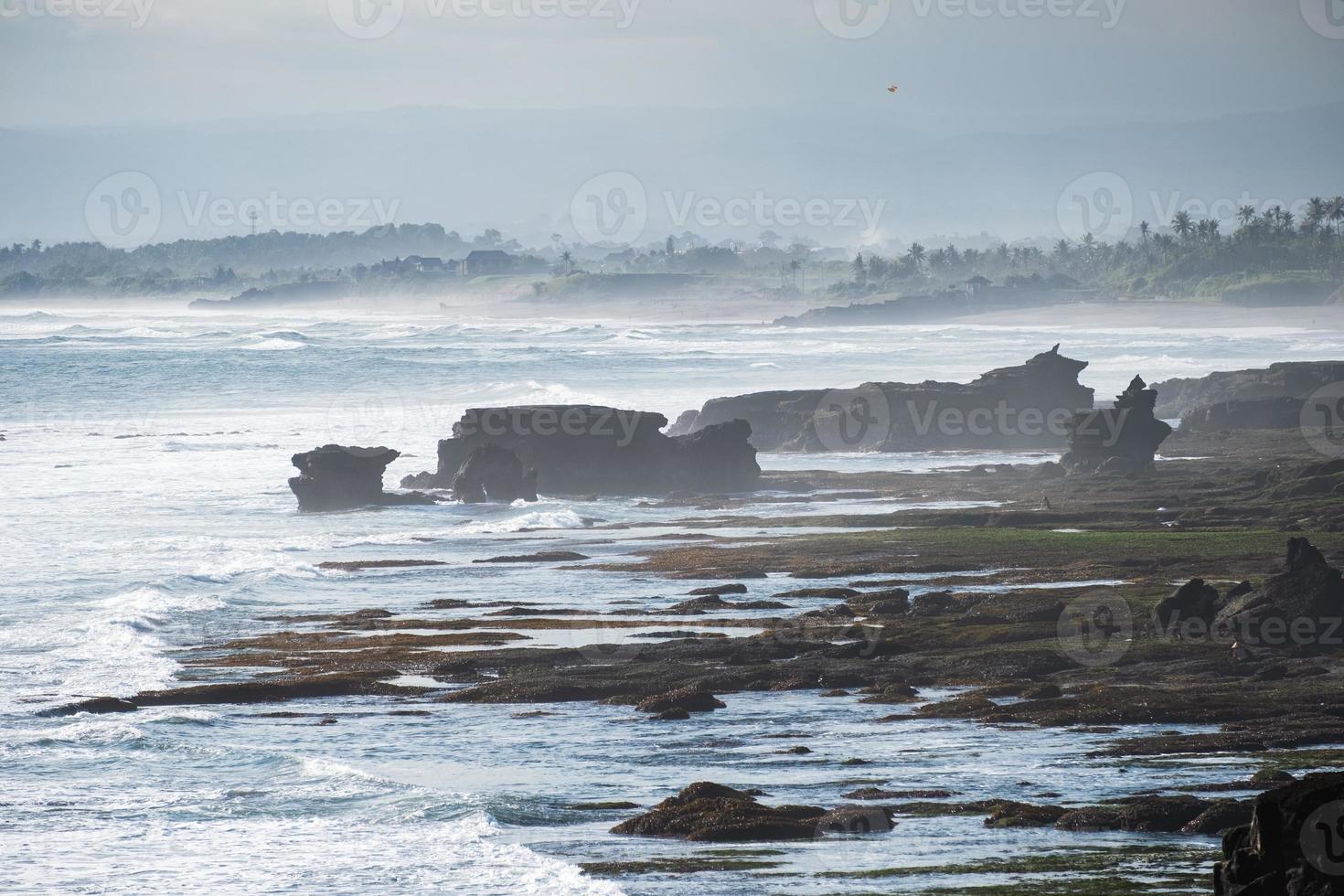 landschap van golven die rotsen raken aan de kustlijn foto