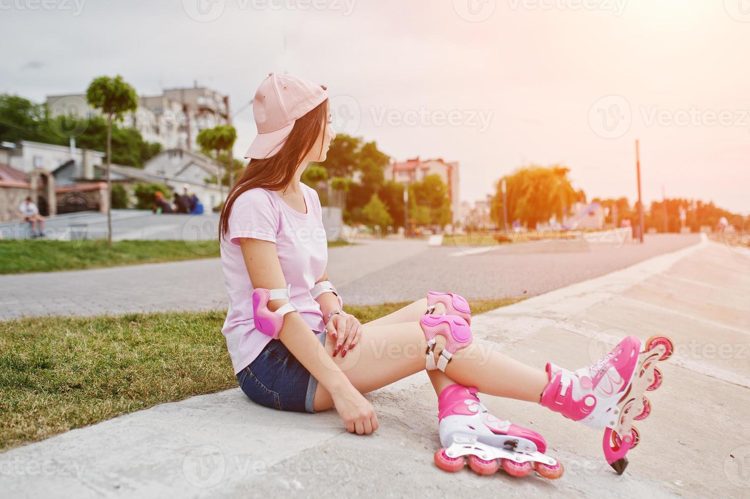 portret van een prachtige jonge vrouw in casual kleding en pet zittend op de grond naast het meer. foto