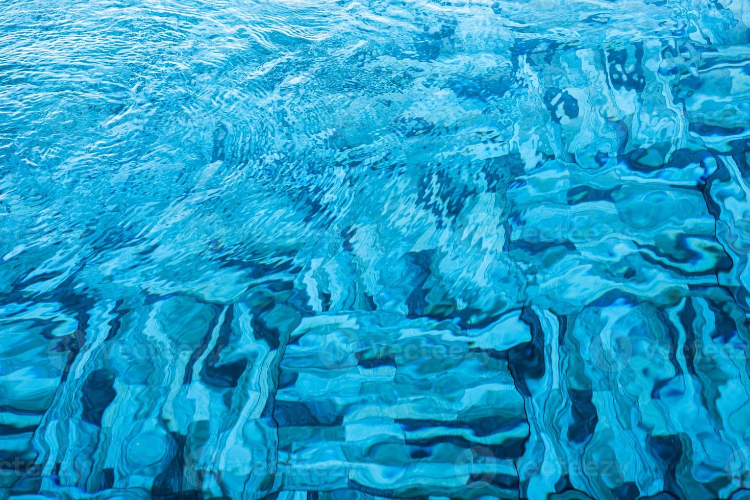 gegolfd transparant blauw zwembadoppervlak foto