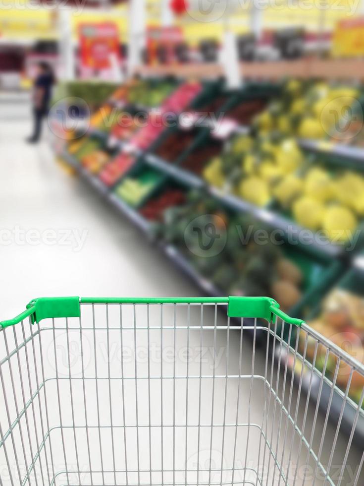 winkelen voor wat groenten en fruit in de supermarkt met winkelwagentje foto