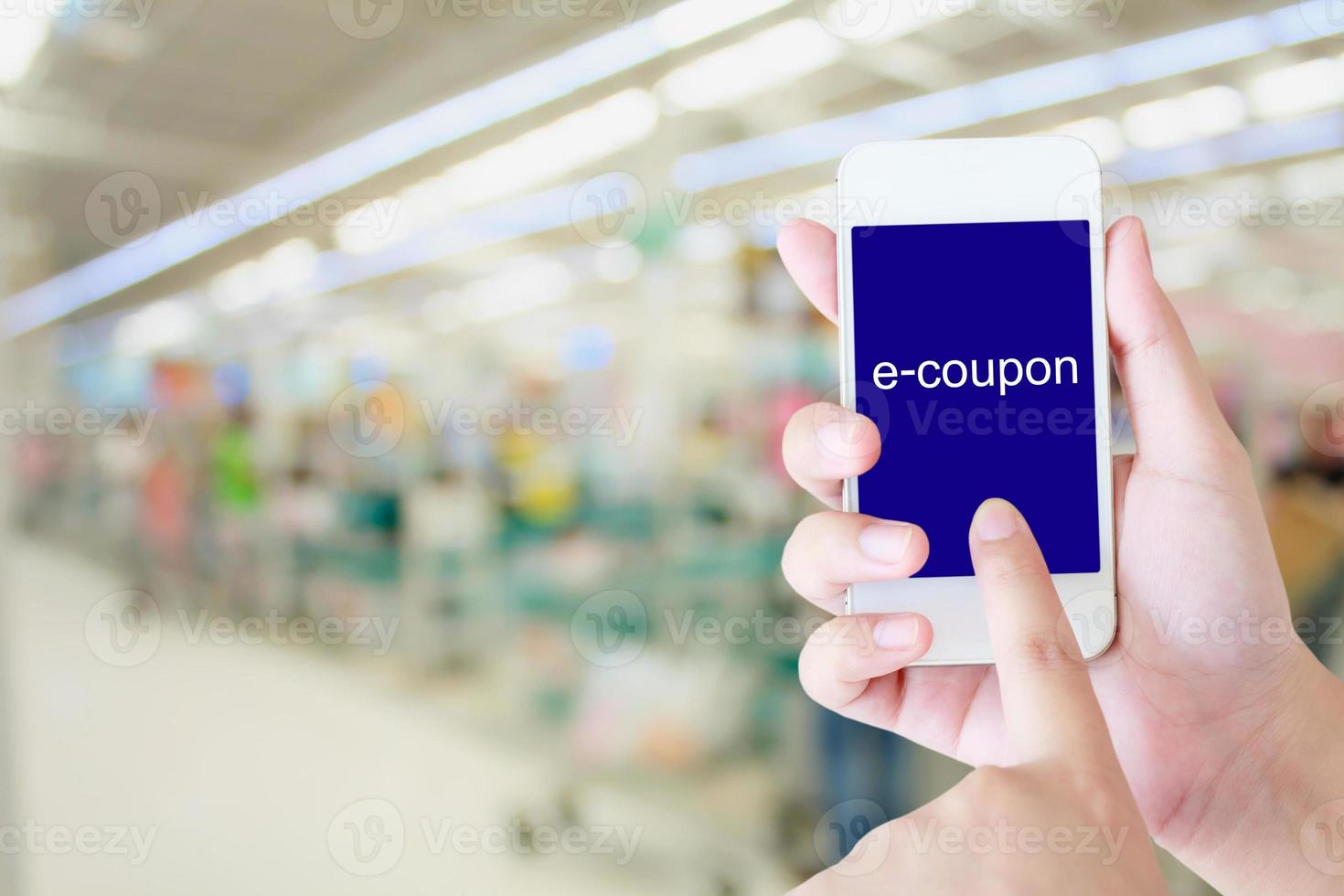 hand met mobiele telefoon bij supermarkt kassa achtergrond, e coupon concept foto