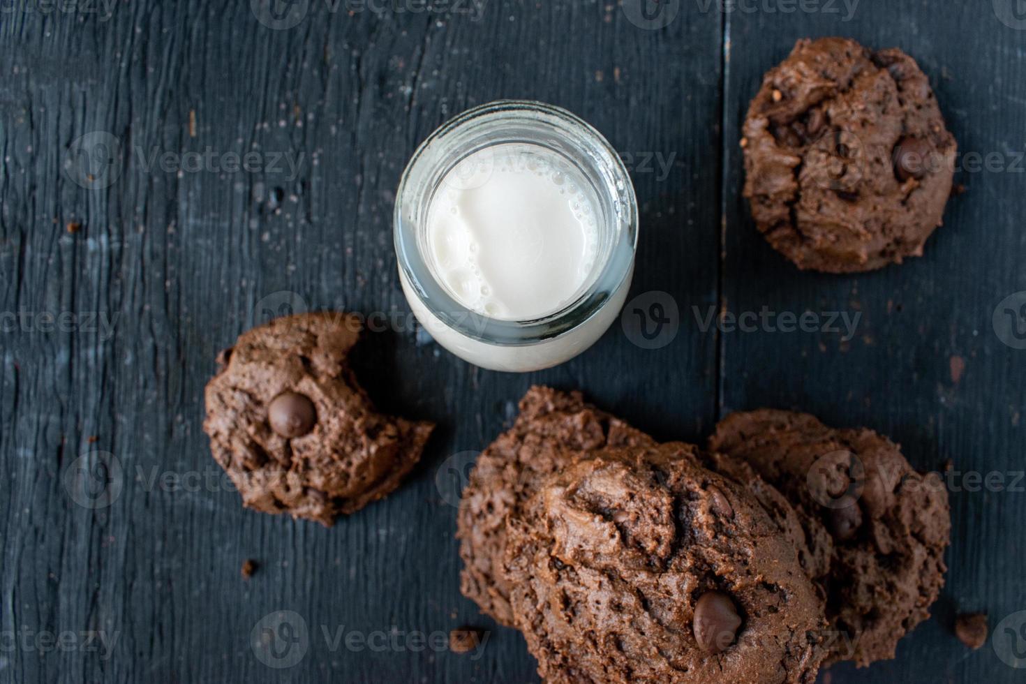 stapel chocoladeschilferkoekjes met melk op rustieke houten tafel foto