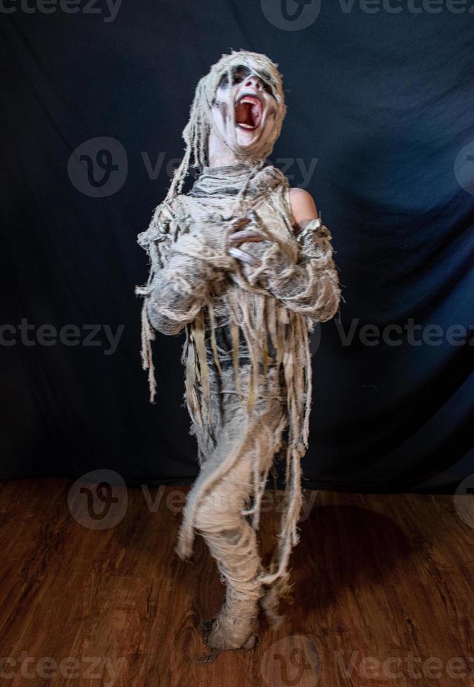 studio-opname portret van jonge jongen in kostuum gekleed als een halloween, cosplay van enge mummie pose op geïsoleerde zwarte achtergrond foto