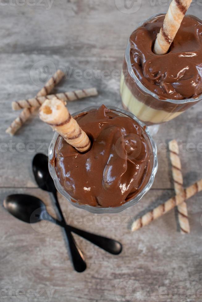 chocolade- en vanillepuddingparfait met gestript koekjesstro dessert bovenaanzicht foto