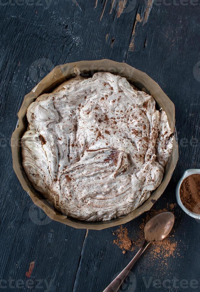 rond gebakken brownie gegarneerd met meringue en chocolade swirls plat gelegd foto