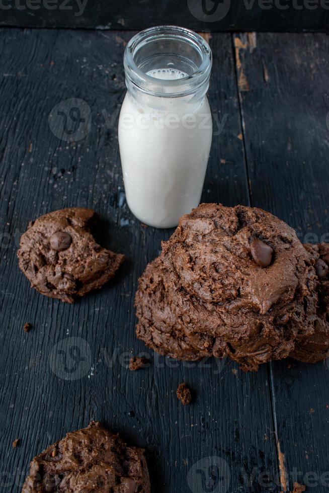 stapel chocoladeschilferkoekjes met melk op rustieke houten tafel foto