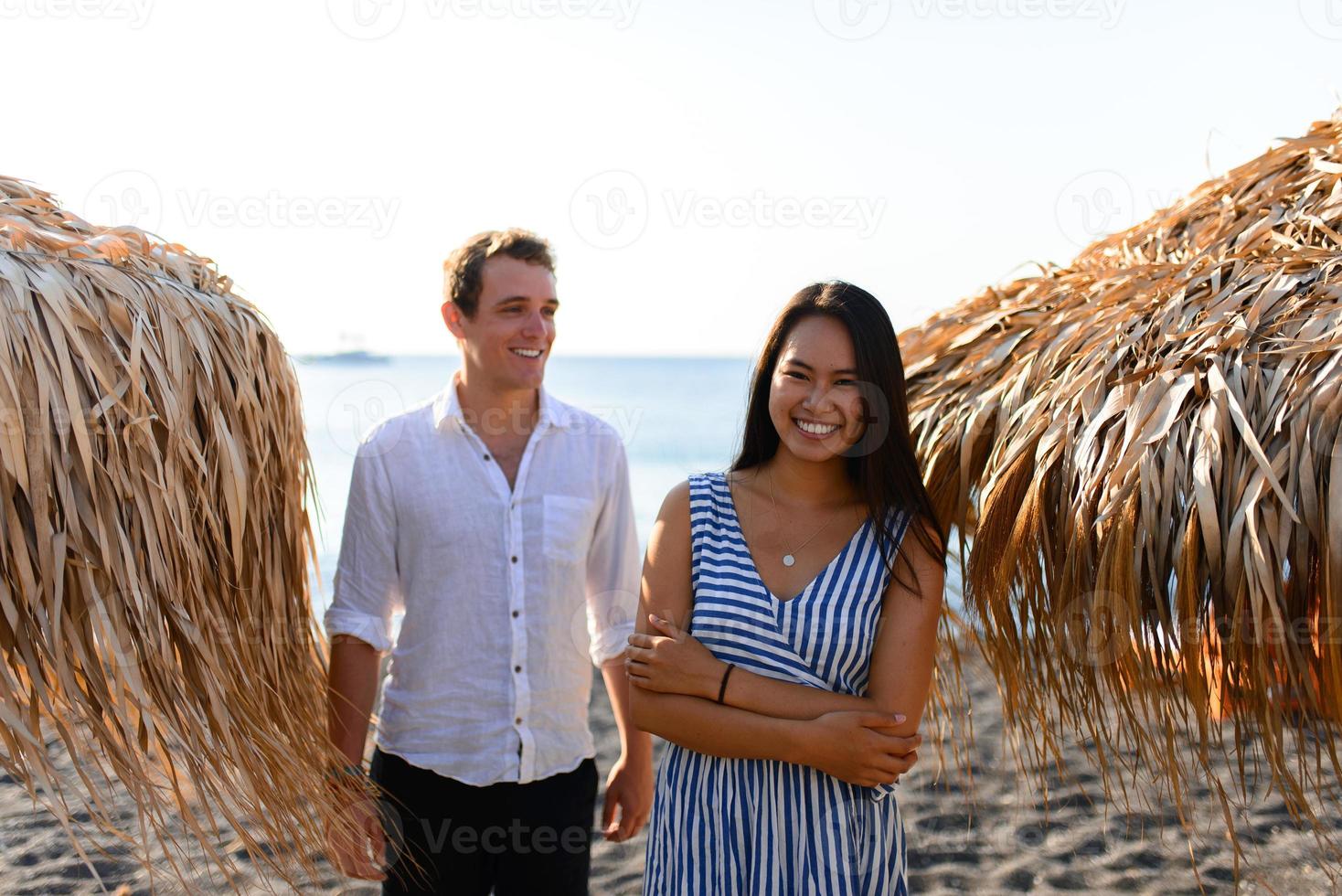 de jongen en het meisje op de achtergrond van de zee. focus op het meisje. voor hen zijn bungalows. geschoten op het strand van Santorini. foto