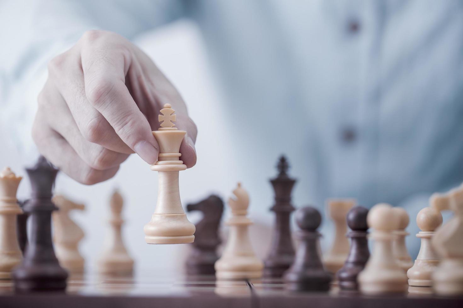 zakenmanspel met schaakspel in competitiesuccesspel, conceptstrategie en succesvol management of leiderschap foto