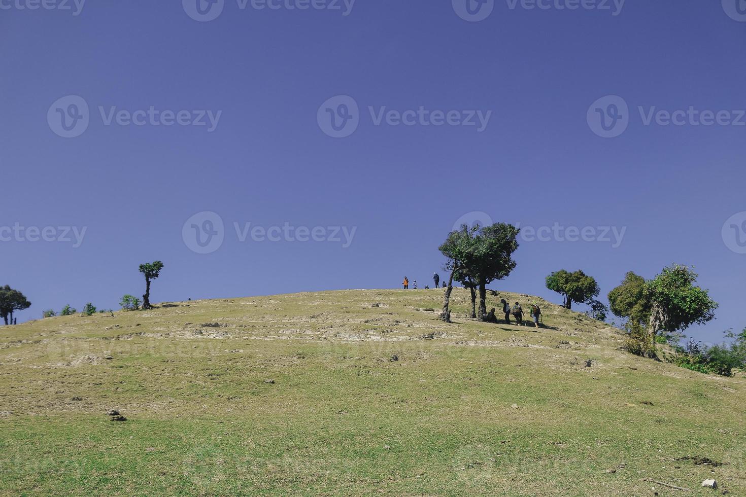 groep wandelaars wandelen langs de groene heuvels, achteraanzicht. reistoerisme ontdekkingsconcept foto