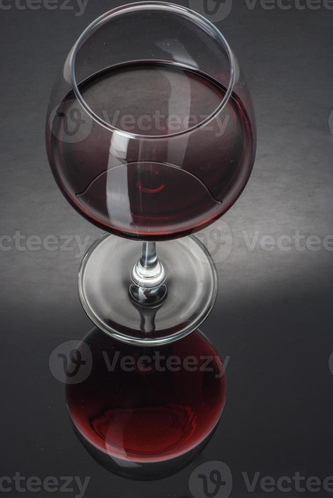 glas gevuld met wijn op een zwarte tafel foto