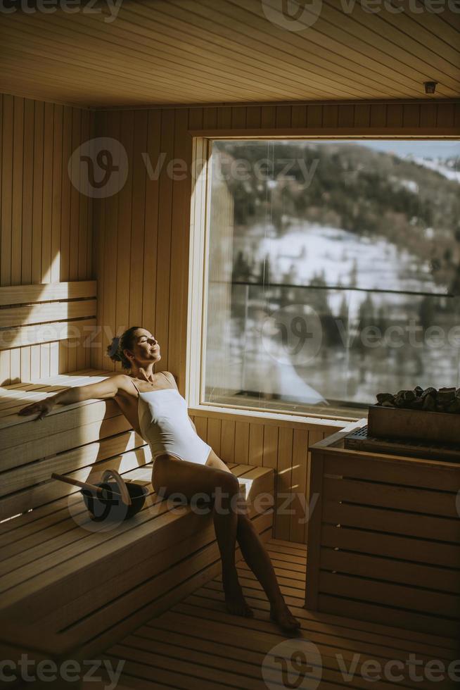jonge vrouw ontspannen in de sauna foto