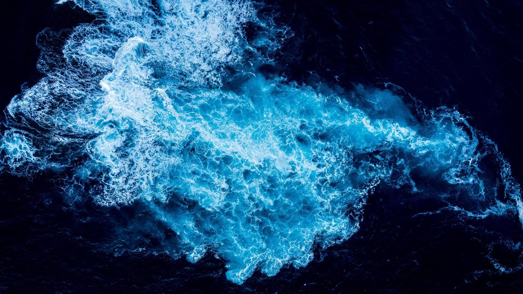 luchtfoto van wit water veroorzaakt door onderwaterrotsen foto