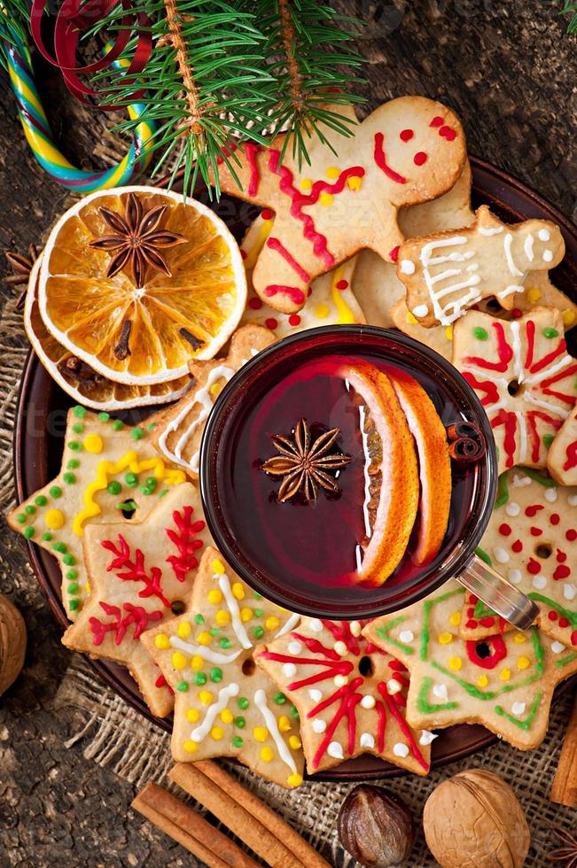 verwarmende glühwein, kruiden en peperkoekkoekje op een houten ondergrond in rustieke stijl foto