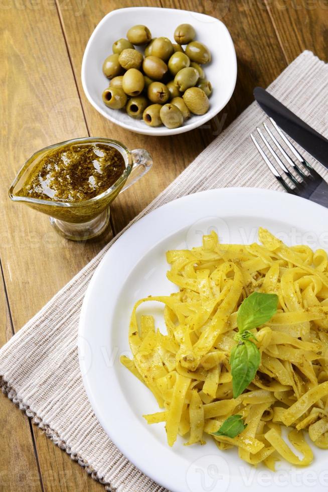 heerlijke pasta met pesto op plaat op tafel close-up foto