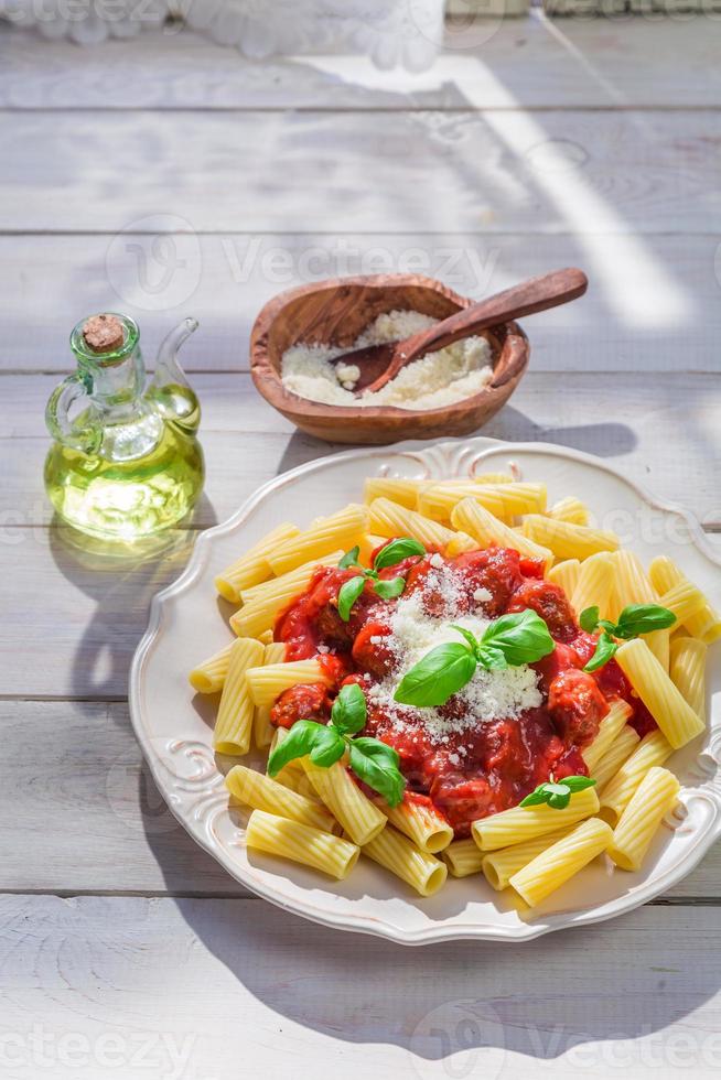 smakelijke pasta penne met tomatensaus en parmezaan foto