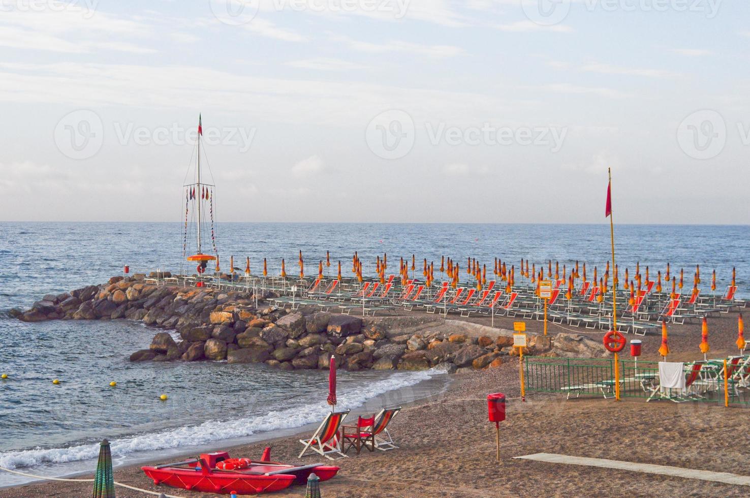 kuststrand met parasol en ligstoelen foto