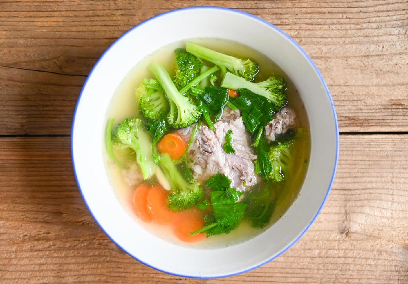 duidelijke soepkom met varkensribbetjes groente wortel broccoli soep en selderij, voedsel gezond menu foto