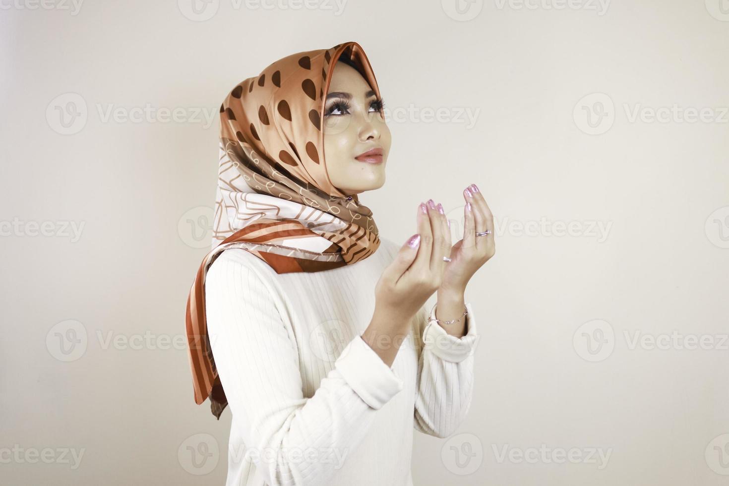 gelukkig mooi aziatisch moslimmeisje dat een hoofddoek draagt die tot god bidt. foto