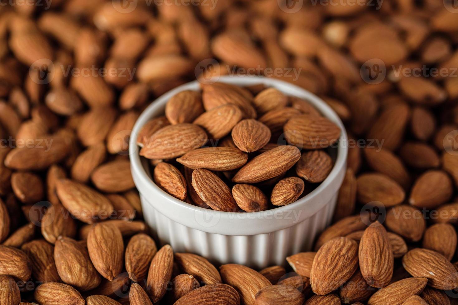 amandelen in houten kom op houten table.diet grondstof foto