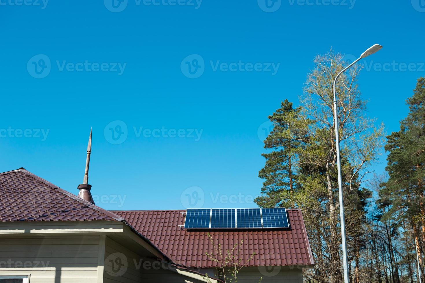 zonnepanelen op het dak van een privéhuis met één verdieping op het platteland. milieuvriendelijk gebruik van zonne-energie, een alternatieve bron. zorg voor de natuur, behoud van hulpbronnen foto