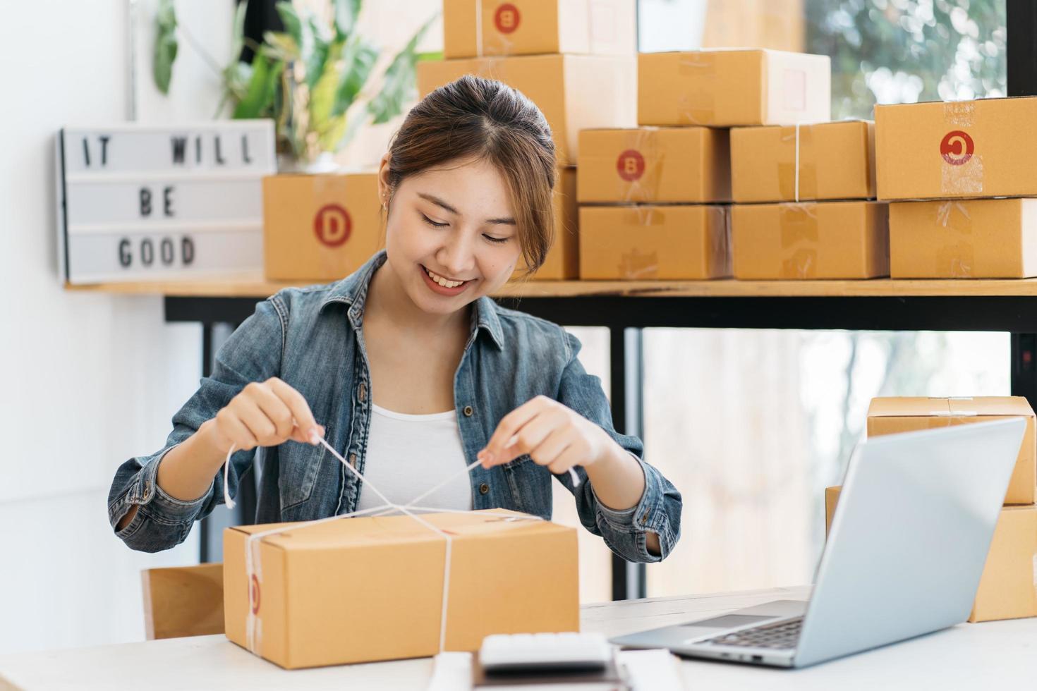 kleine ondernemer mkb-ondernemer van jonge aziatische vrouwen die met laptop werken om thuis online te winkelen, vrolijk en blij met doos voor verpakking in huis, eigen bedrijf opstarten voor online zaken foto