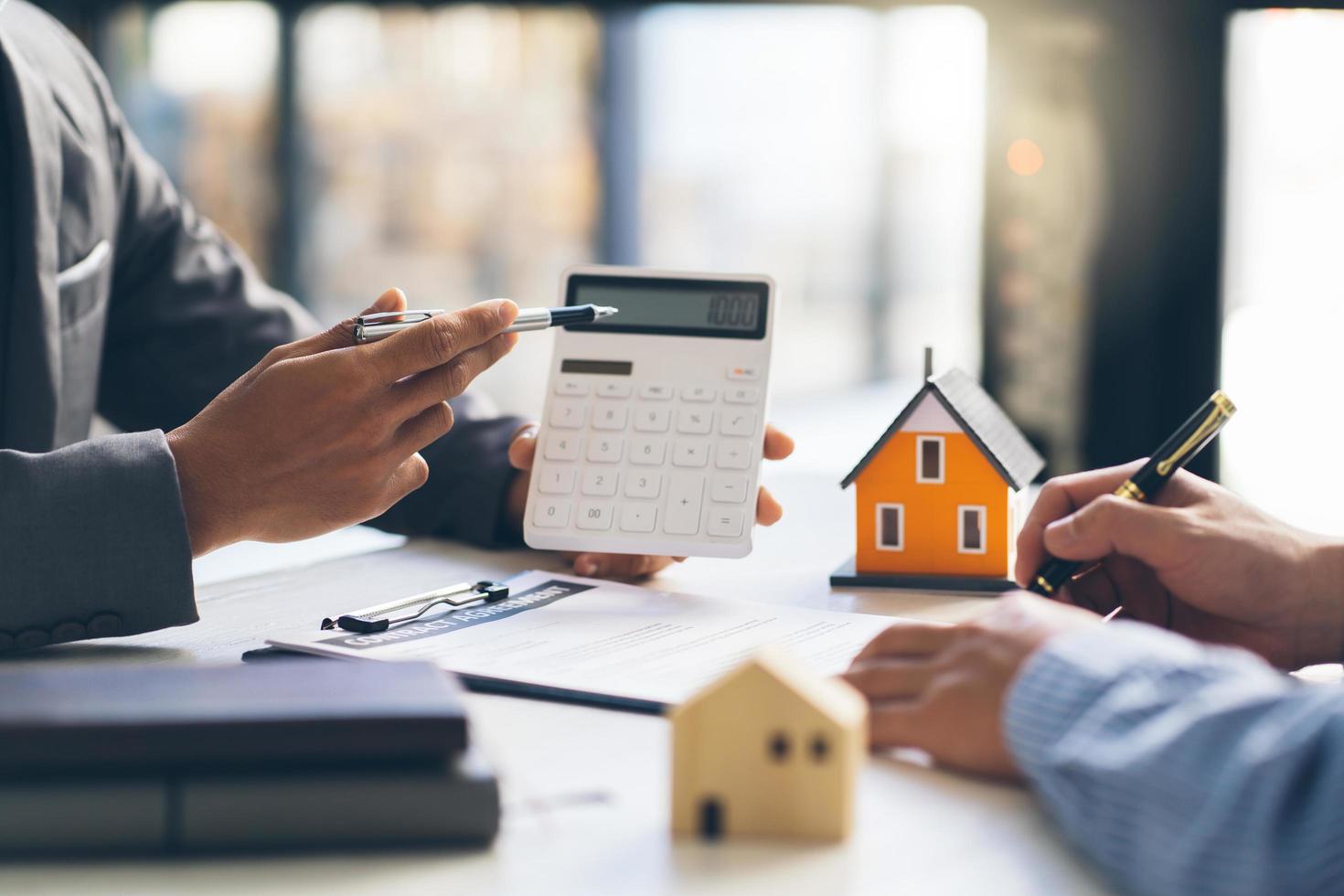 huismodel met agent en klant bespreken voor contract om onroerend goed of onroerend goed te kopen, verzekeringen of leningen te krijgen. foto