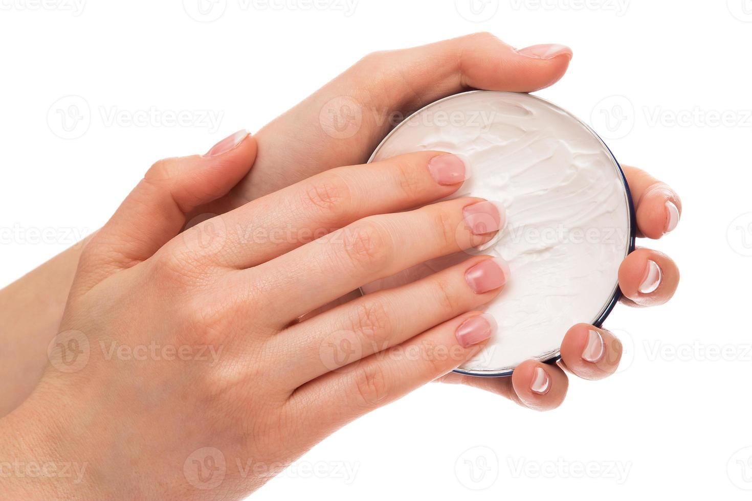 vrouw die vochtinbrengende crème op handen aanbrengt foto