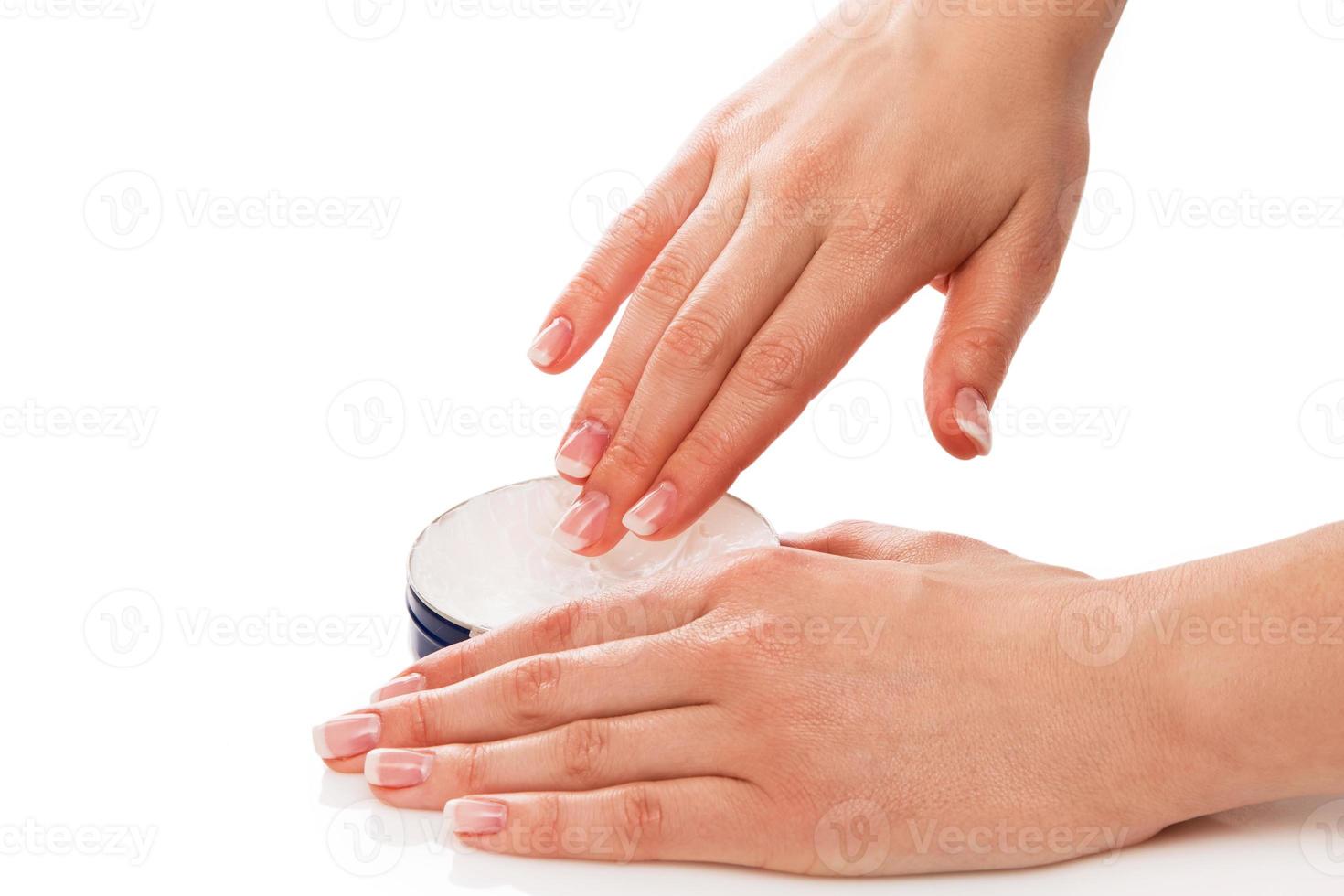 vrouw die vochtinbrengende crème op handen aanbrengt foto