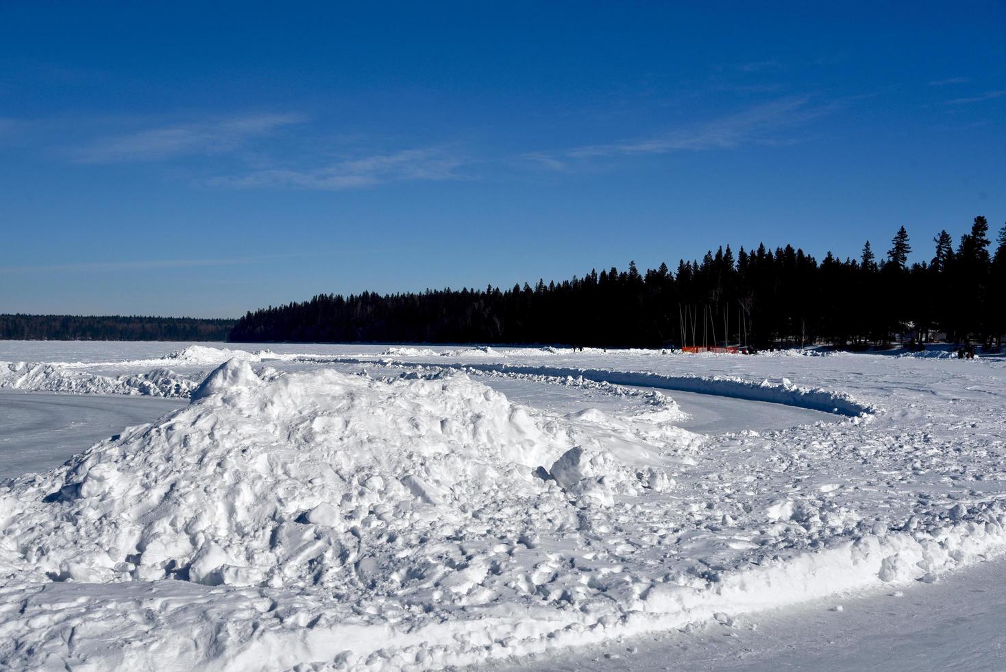 de besneeuwde kustlijn van een bevroren meer foto