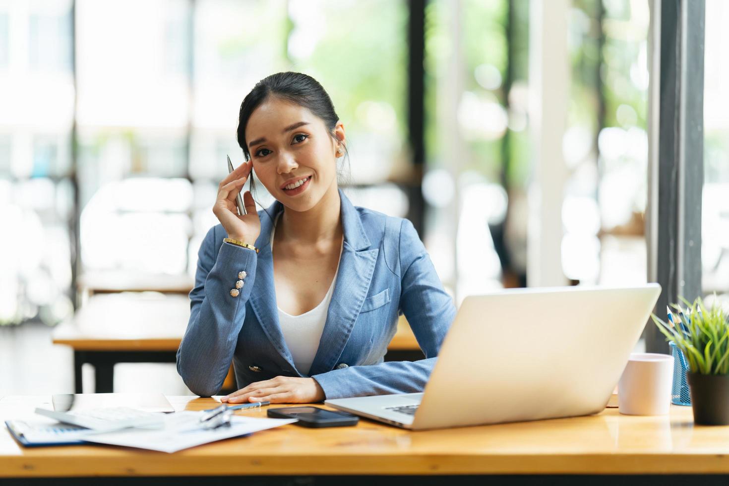 portret van aziatische jonge vrouw die op laptop werkt op kantoor, financieel en investeringsconcept. foto