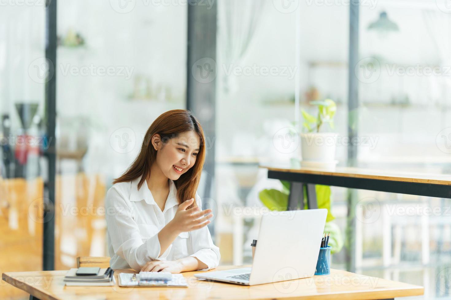 portret van Aziatische jonge vrouw die op laptop en financieel verslag op kantoor werkt. foto