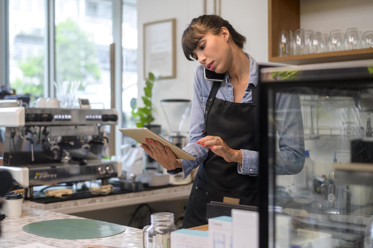 jonge servicegerichte barista-vrouw die in de coffeeshop werkt? foto