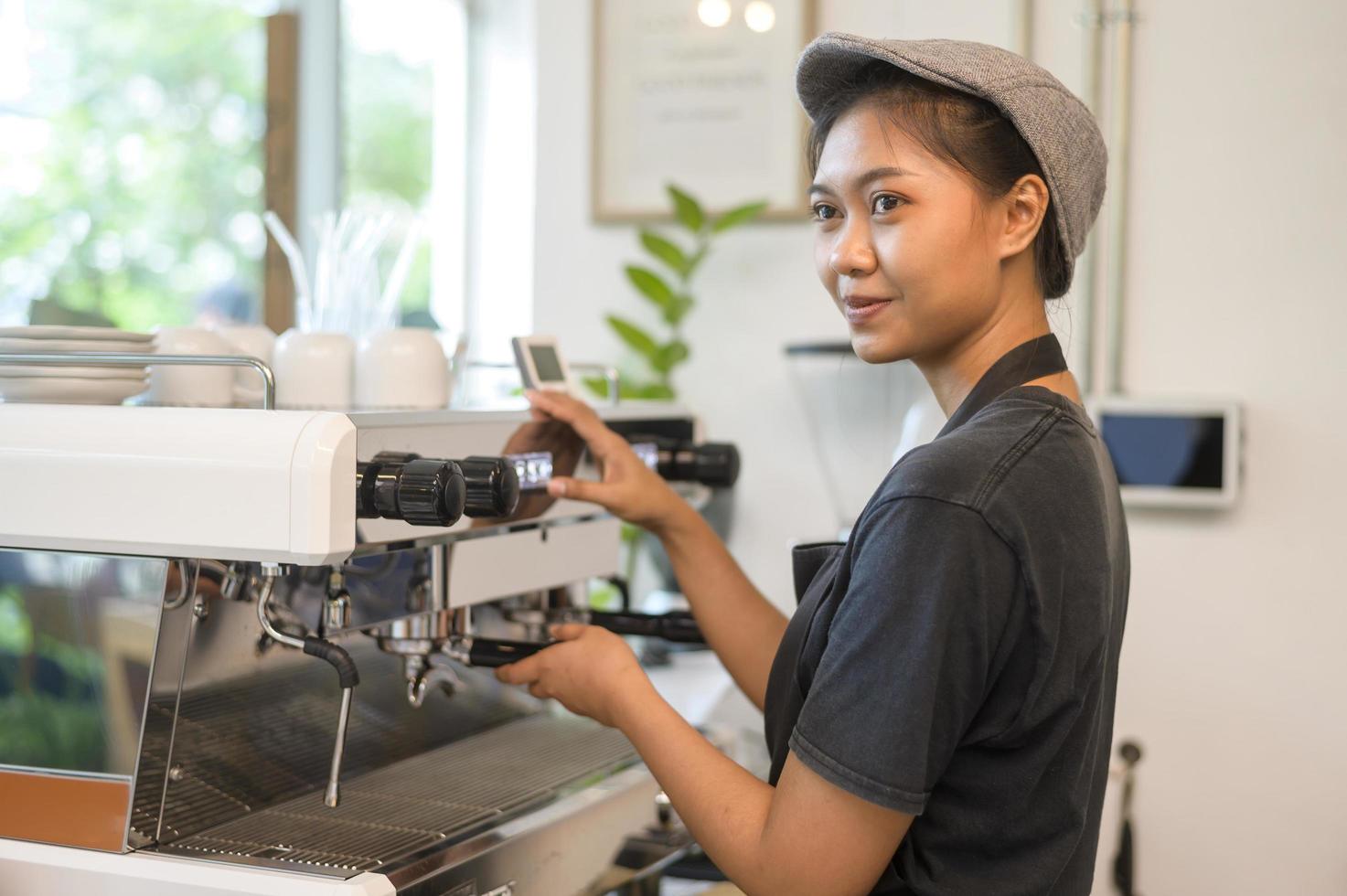 jonge servicegerichte barista-vrouw die in de coffeeshop werkt? foto