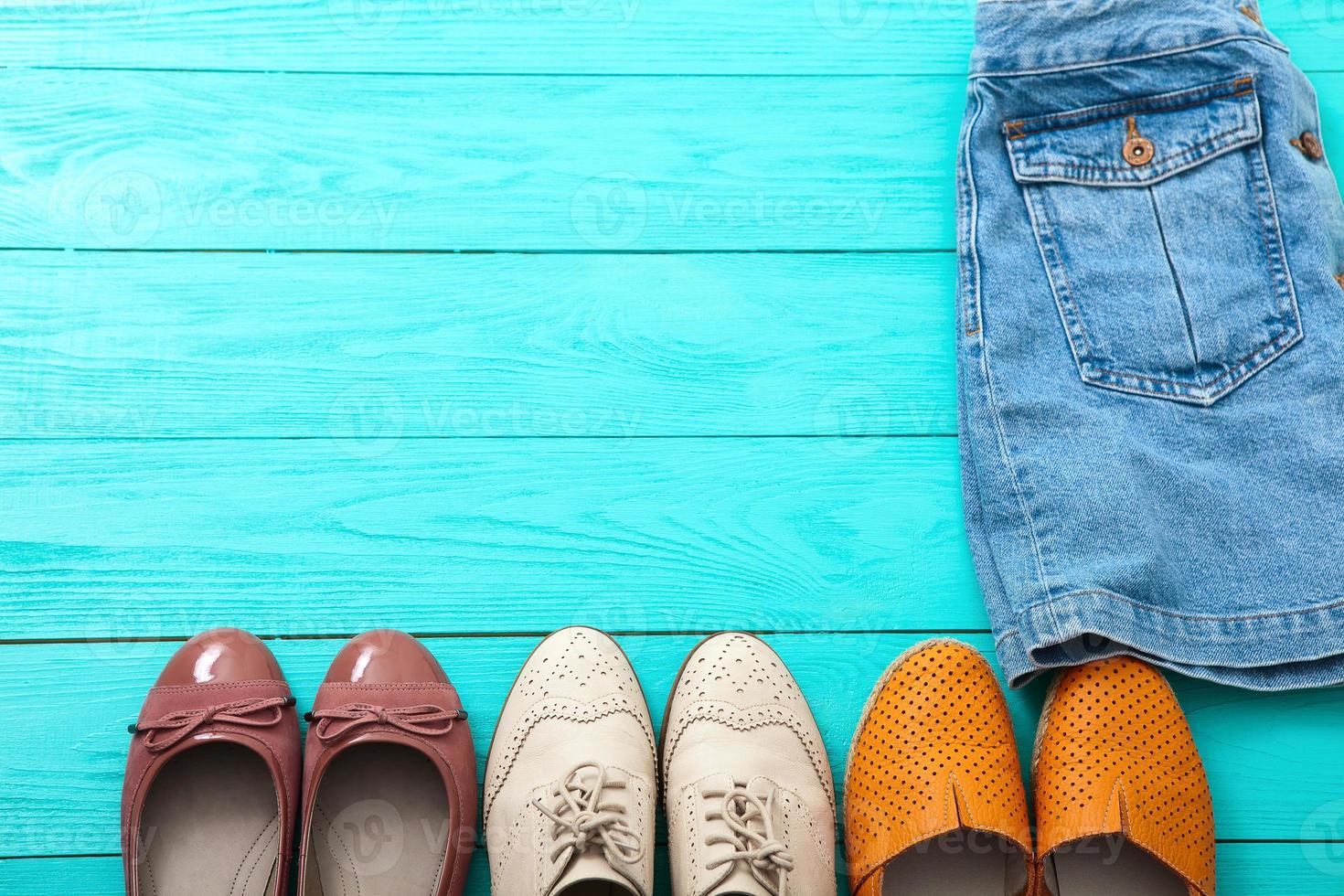 verschillende paren vrouwelijke schoenen op blauwe houten vloer, bovenaanzicht en kopieerruimte foto