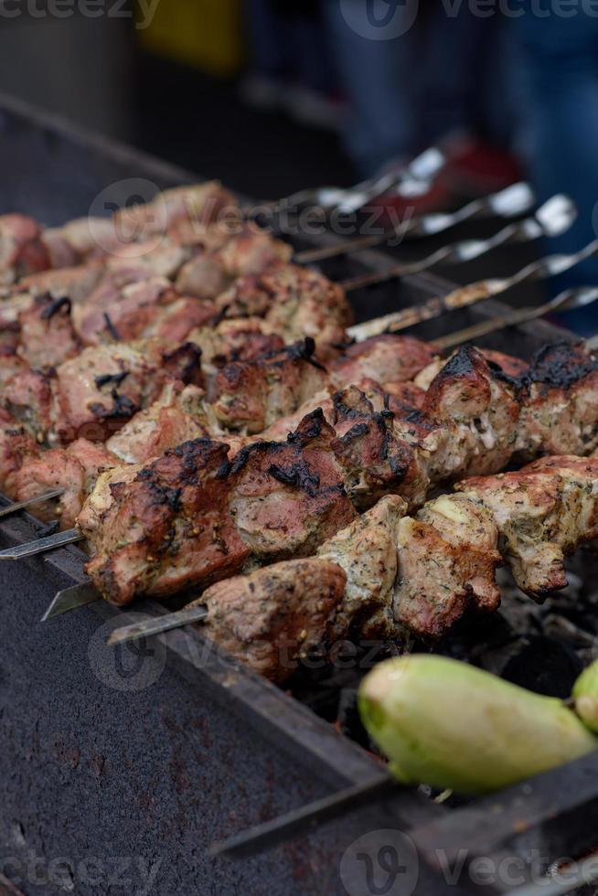 Gegrilde spiesjes van vlees op de kolen, met rook. straatvoedsel. foto