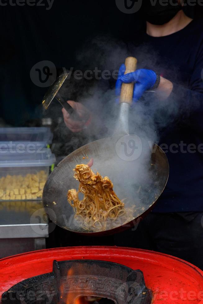 een chef-kok bereidt Chinees eten op een straatvoedselfestival. foto