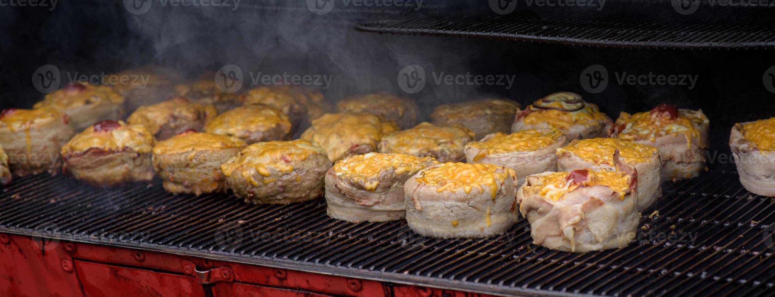 handgemaakte hamburgers tijdens het straatvoedselfestival, roken tijdens het koken. foto