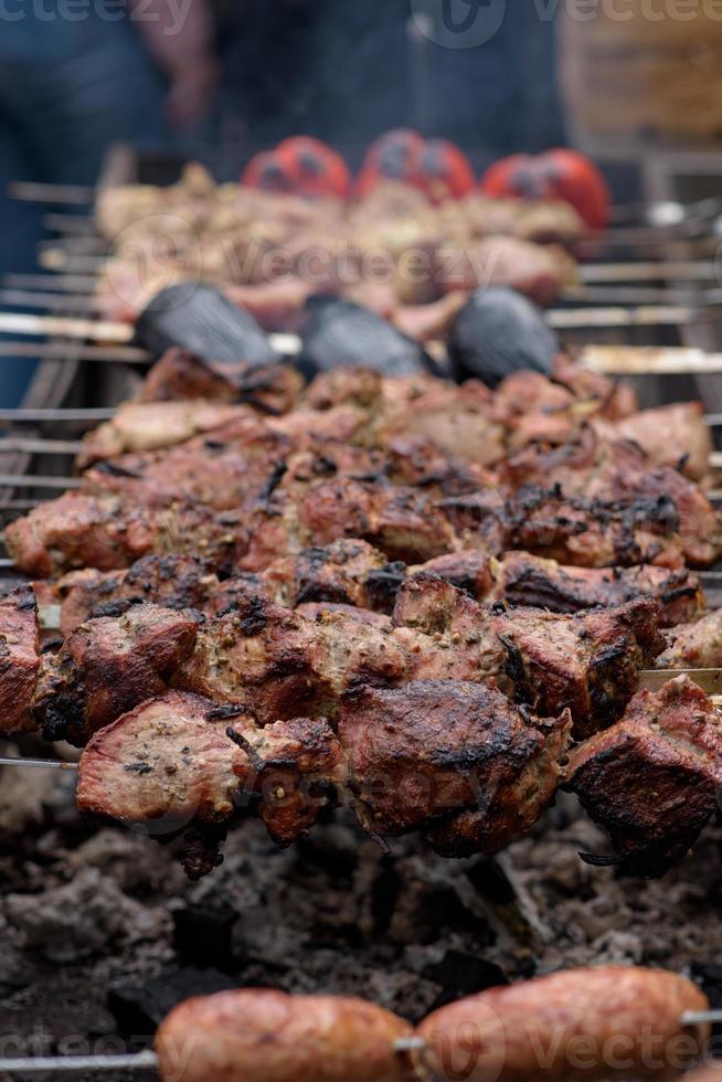 Gegrilde spiesjes van vlees op de kolen, met rook. straatvoedsel. foto